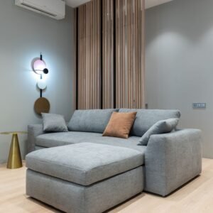 Interior of modern living room with sofa with pillows next to round table under conditioner